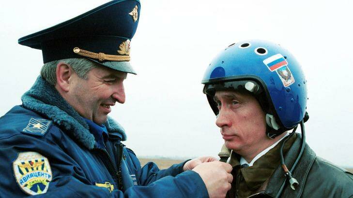 Russian air force general Alexander Kharchevsky adjusts a helmet on Vladimir Putin, then Russia's acting president, before he flew into Chechnya in a fighter jet on March 20, 2000.  Photo: ITAR-TASS via AP