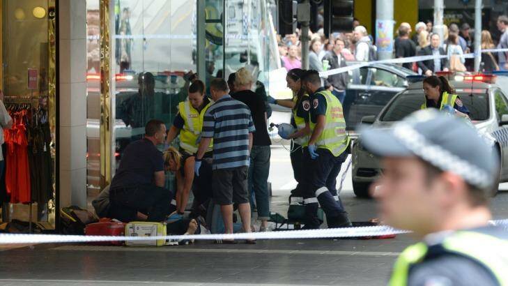 Ambulance paramedics treat an injured pedestrian on Bourke Street. Photo: Justin McManus