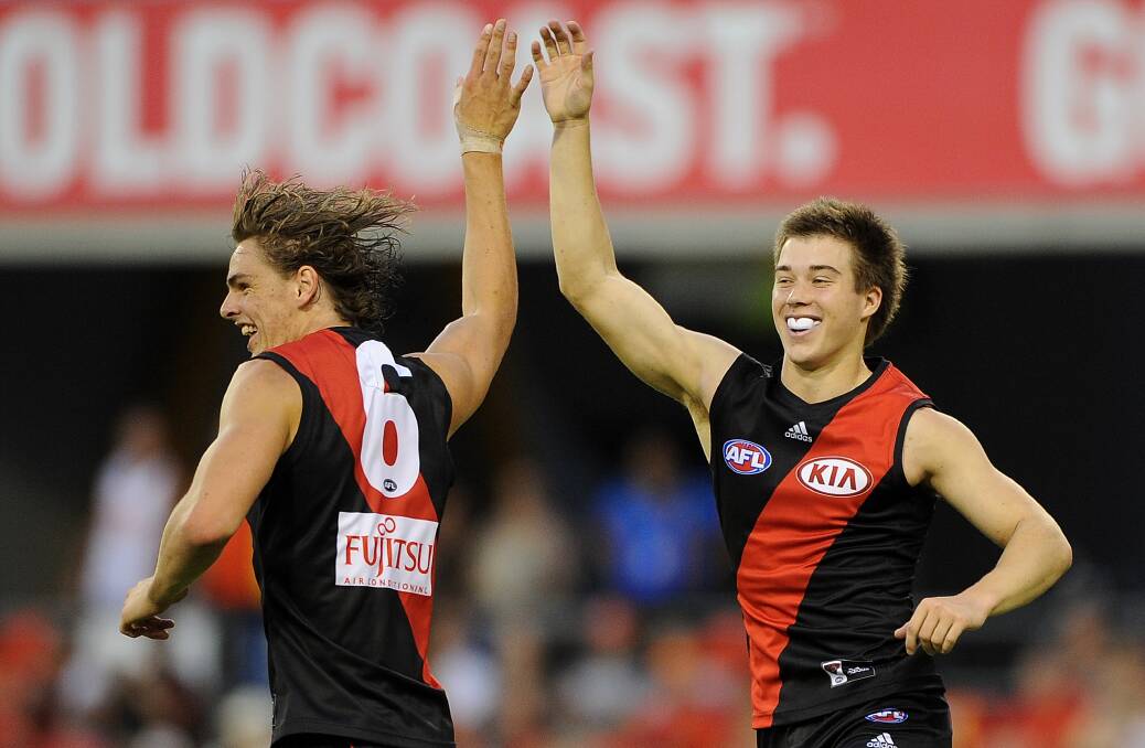 Zach Merrett (right) congratulates teamate Joe Daniher on kicking a goal in Essendon’s one-point loss to Gold Coast. Merrett earned praise from coach Mark Thompson for his efforts in his first game. Picture: GETTY IMAGES