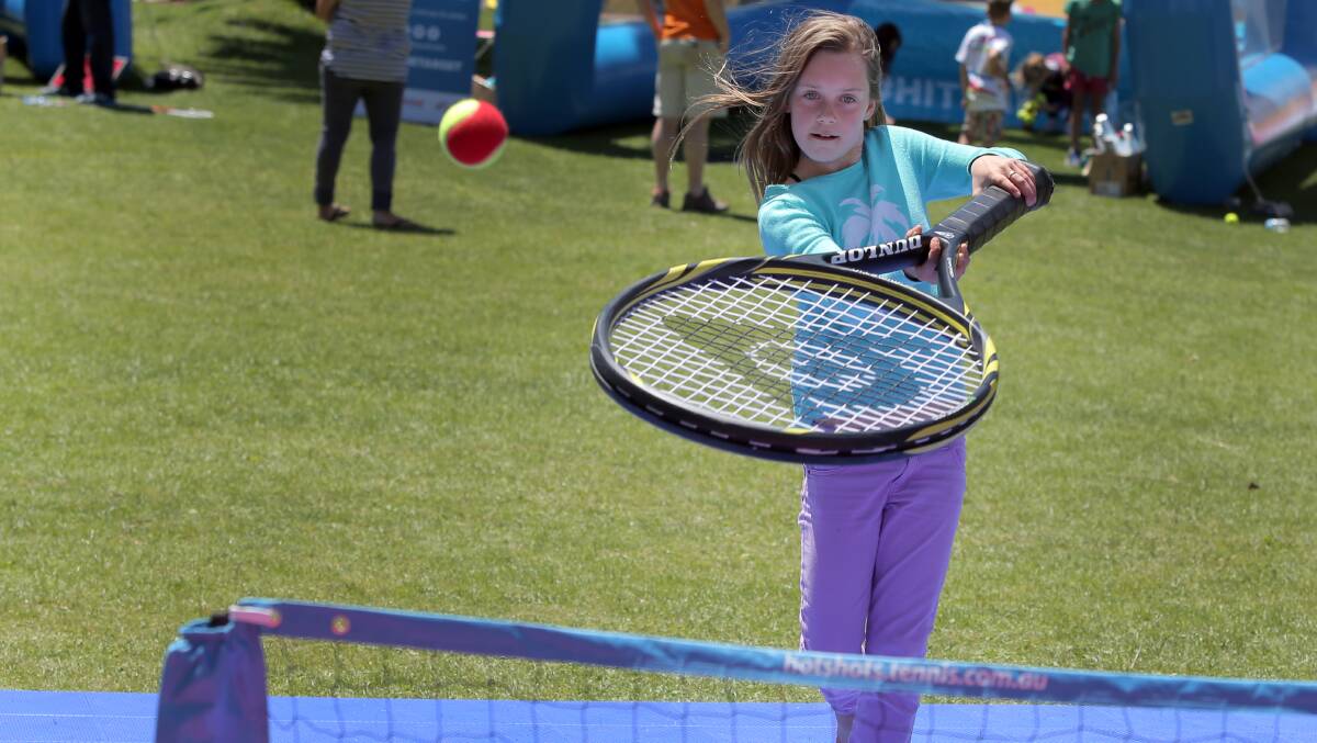 Warrnambool’s Maya Lowen, 11, tries playing tennis with a giant racquet at the Tennis-tacular on the Civic Green. 141115RG02 Picture: ROB GUNSTONE