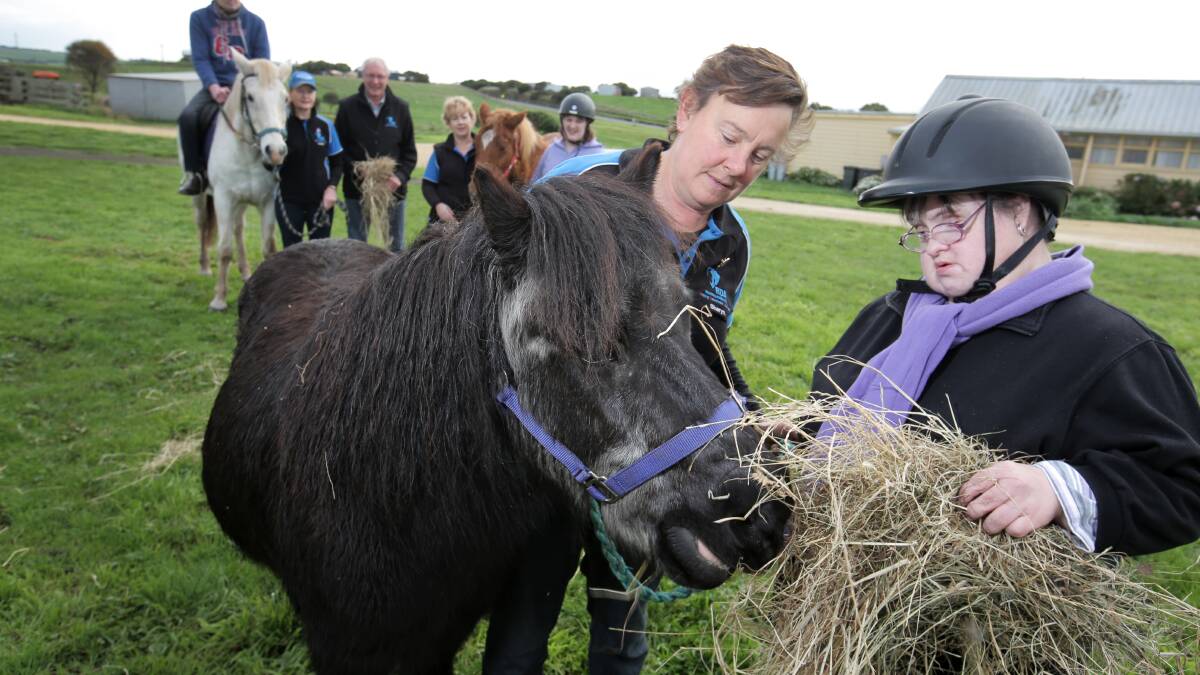 Riding Develops Abilities coach Sharyn van Someren and client Cherie Kearney feed Winkie the pony following news of a $3500 donation to the program.   Picture: ROB GUNSTONE