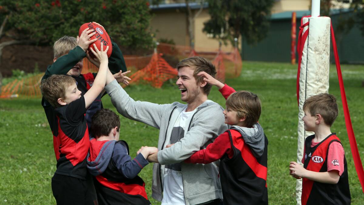 Essendon player Martin Gleeson returned to St Patrick’s Primary School in Koroit yesterday to unveil his former school’s new goal posts. He also managed to fit in a kick-to-kick session with young fans (from left) Luke Turner, Louis Sharman, Tom Foster, Rory Waterson and Hamish Dobson.  140915LP13 Picture: LEANNE PICKETT