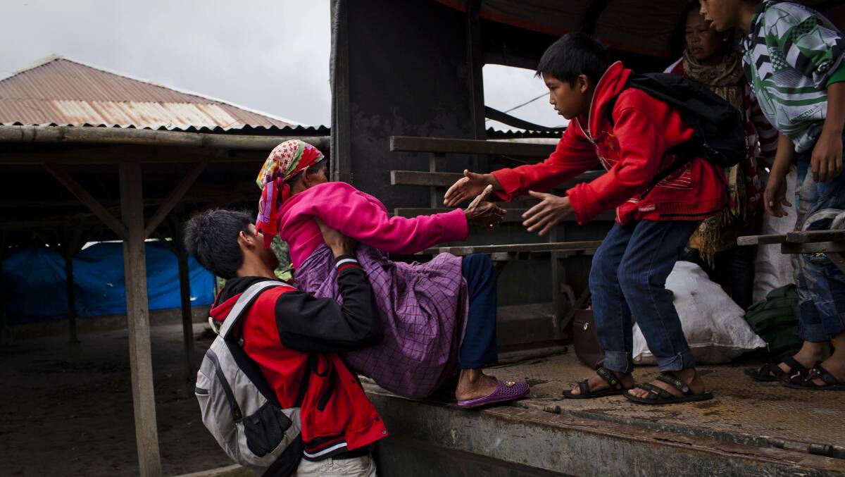Villagers evacuate to a temporary evacuation center following another eruption at Mount Sinabung in Pintu Besi village on January 3, 2014 in North Sumatra, Indonesia. Picture: Getty