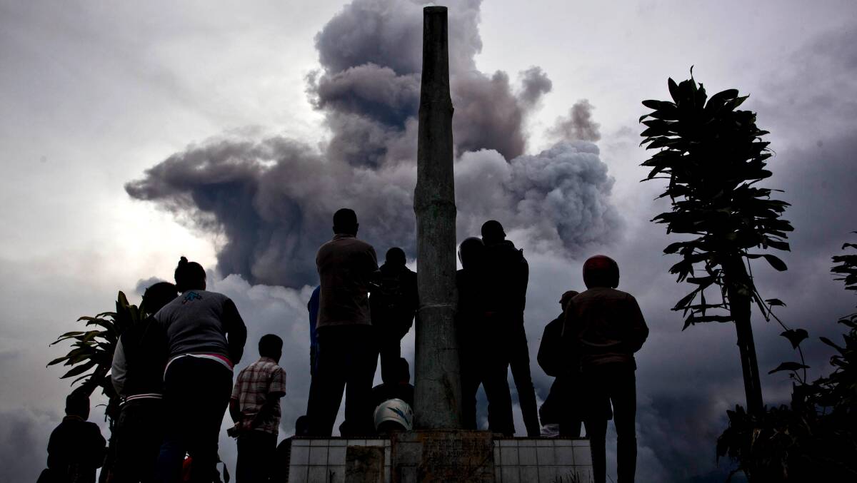 People watch as Mount Sinabung spews pyroclastic smoke on January 3, 2014 in Karo District, North Sumatra, Indonesia. Picture: Getty