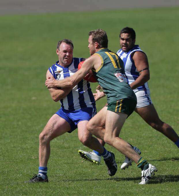 Russells Creek player Shaun McDougal is confronted by Old Collegians opponent Josh Dwyer as Kangas teammate Ali Clark provides a way out of trouble. 