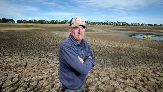 Hamilton Racing Club president Peter Young stands in the dried out main dam.  Without water, the track has become too dry and hard for racing.