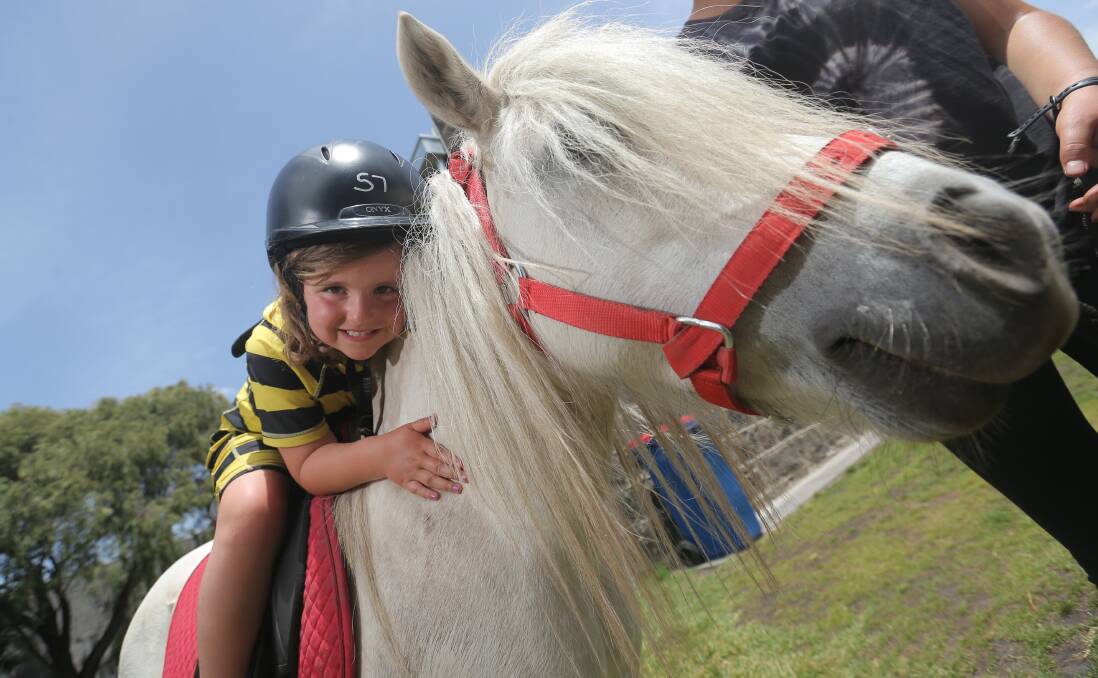 Abra Curran cuddles up to Sparkles from Rundells Mahogany Horse Rides at Port Fairy earlier this month.