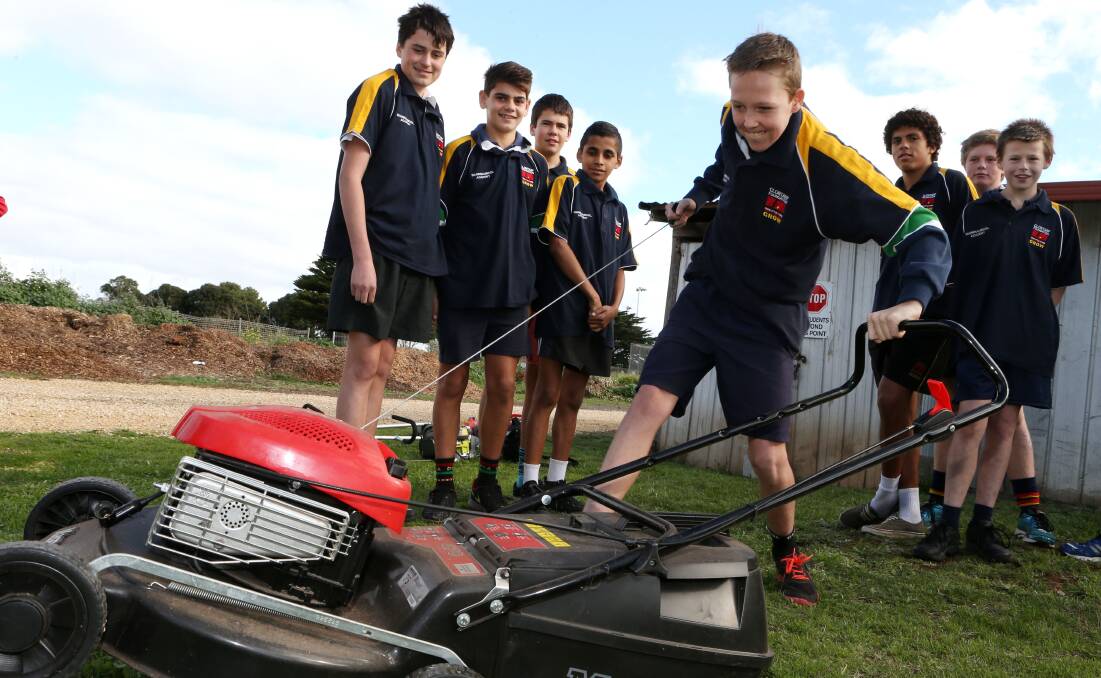 After some training from Bunnings staff, John Williams, 14, starts a mower as part of Warrnambool Clontarf Academy’s Backyard Blitz program. 