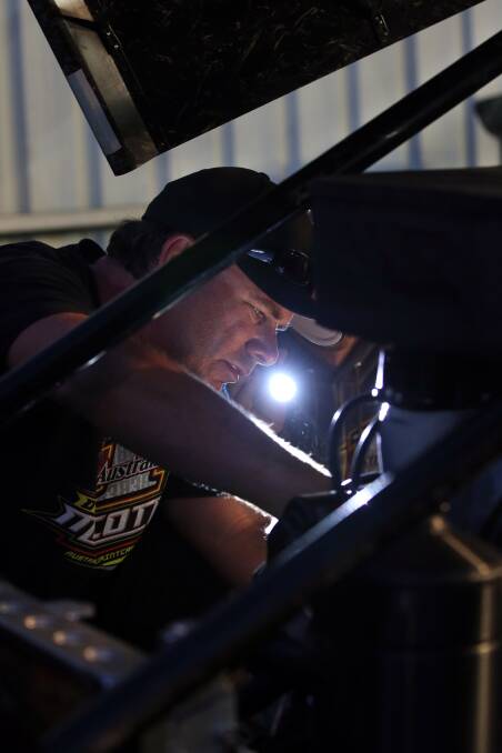 Gary Tate works on the engine, with the help of torchlight, to keep Dave Murcott mobile. 