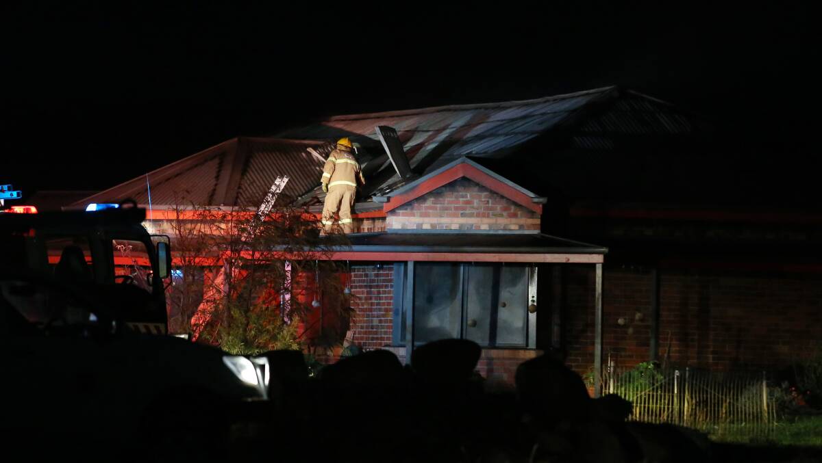 CFA members inspect the roof space of a home that was destroyed by fire last night. Picture: DAMIAN WHITE