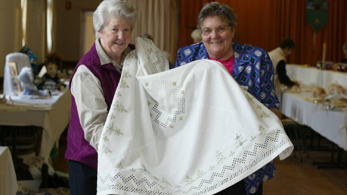 Mary Frenchman (left) shows CWA group president Phyllis Vaughn her intricate hardanger tablecloth. 