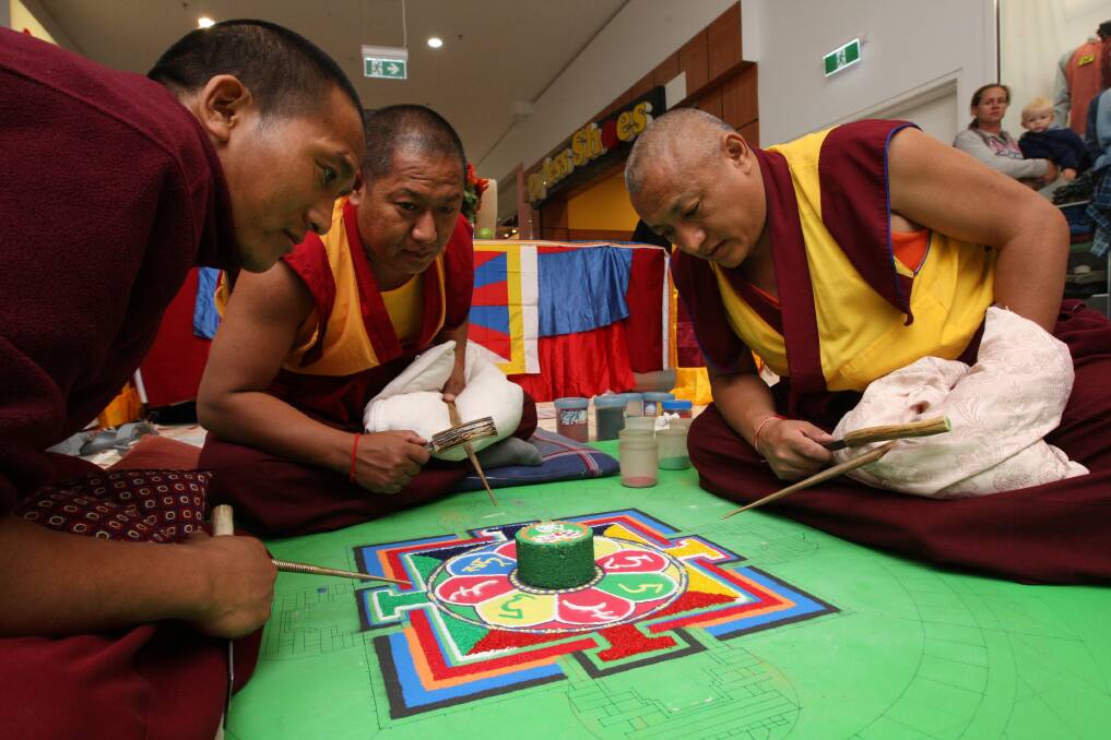 Tibetan Buddhist monks Gelek Tenpa (left), Yama Gyasto and Chime Tsering work on the colourful mandala. 150505AS40 Picture: AARON SAWALL