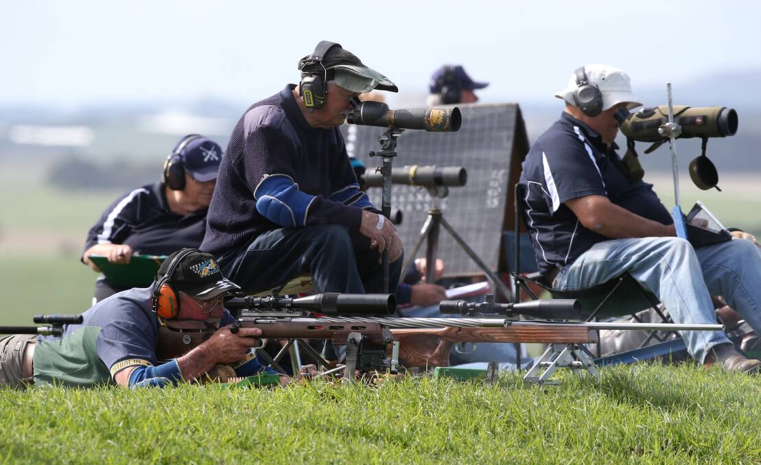 Shooter Noel Osborn, from Victoria, works closely with his coach Bruce Houston (third from left) on the range.