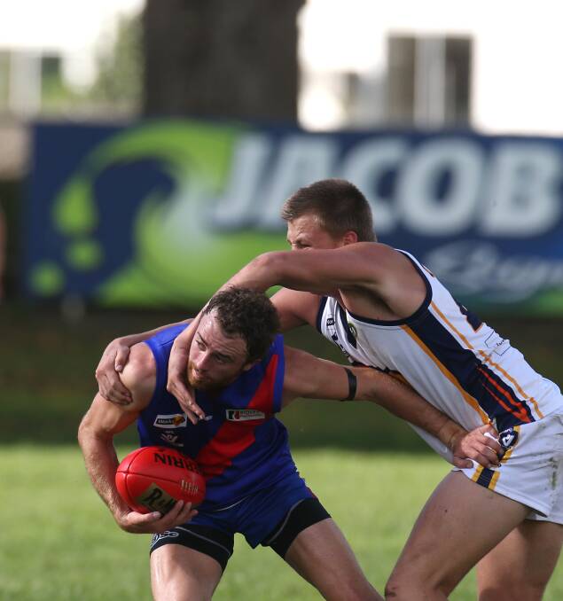 Terang Mortlake player Corey Rounds contends with North Warrnambool Eagles player Sam McLachlan.