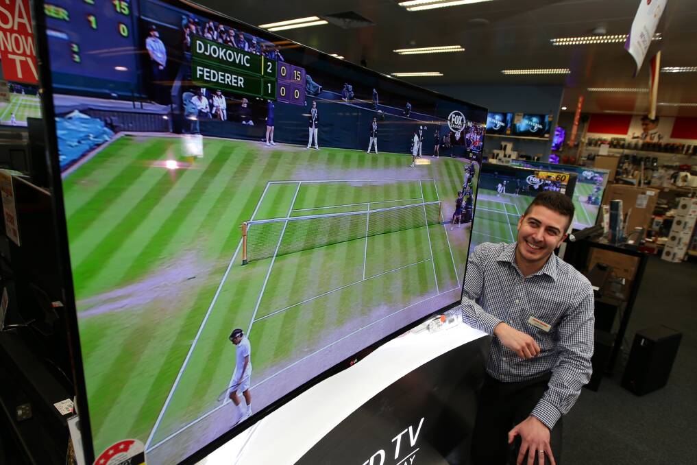 Harvey Norman electrical department franchisee Jarrod Glasunow gets close to the televised sporting action in front of a curved big-screen. 140709DW40 Picture: DAMIAN WHITE