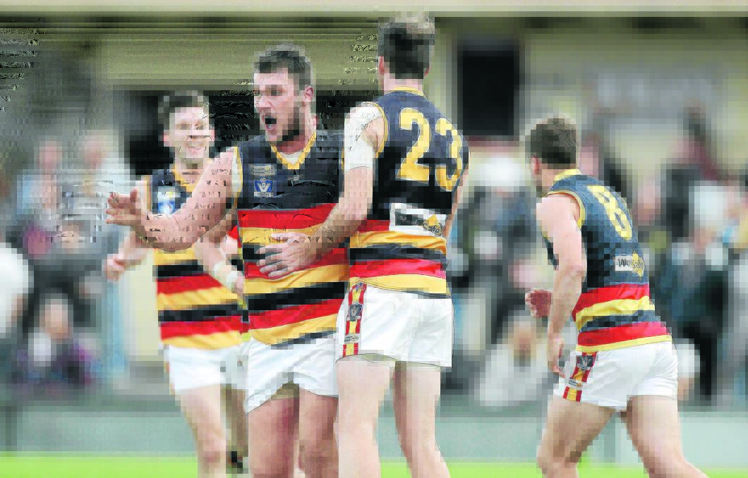 James Keane (second from left) shares the emotion with WDFNL teammates as the visitors surge to victory at Colac's Central Reserve.