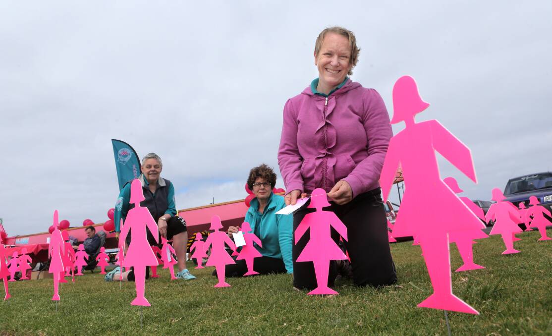 Sue Glaisher (left), Ann Krause and Jan Barton surrounded by a field of pink silhouettes and a pink boat at Warrnambool’s breakwater on Saturday raise awareness of breast cancer. 141011AS01 Picture: AARON SAWALL