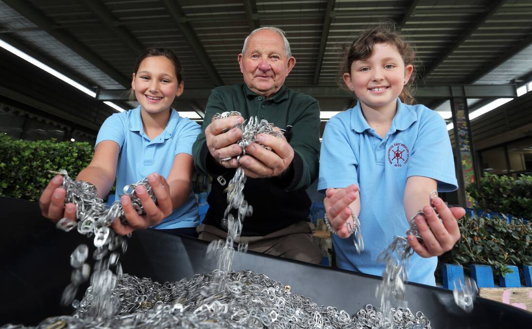East Warrnambool Primary School pupils Isabella Johnson-Schembri, 10, and Ricki Kalman, 9, help Jim “Pa Jimmy” Stacey with a barrow full of can ring pulls which will be melted to make medical parts. 50327RG07 Picture: ROB GUNSTONE