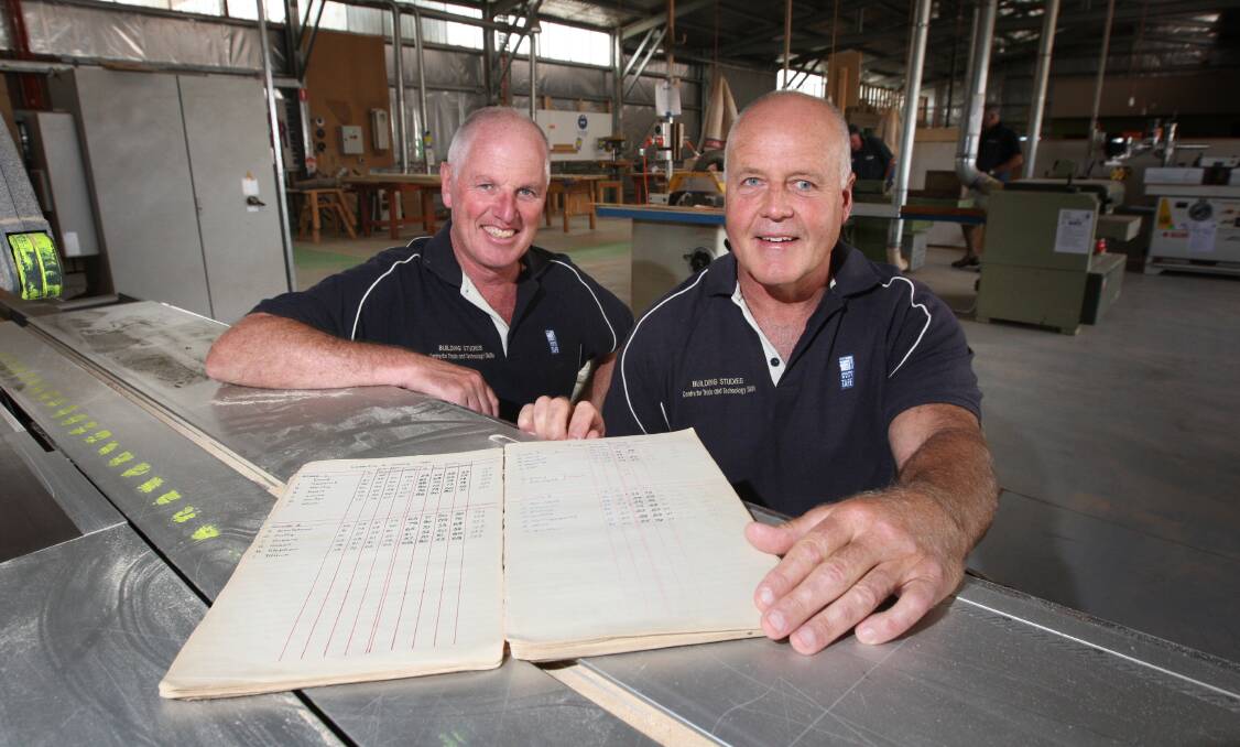 South West TAFE teachers Chris Holloway (left) and Rob Knight with a book of technical school building apprentice students dating from 1946. 
150121AS11 Picture: AARON SAWALL