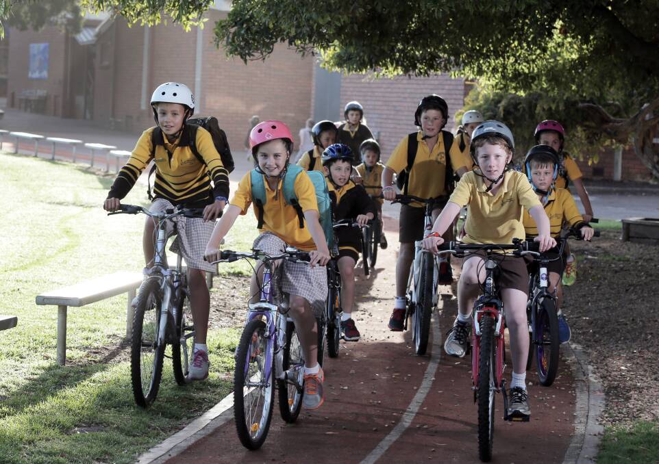 Warrnambool Primary School pupils cruise around the running track on their way the bike shed after arriving yesterday morning on Ride2School Day. 