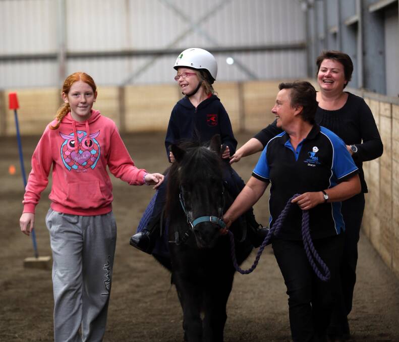 Melanie Sudiro, 7, aboard pony Winky gets a helping hand from Riding Develops Abilities volunteers Lily Farley (left), Leonie Guld and Sharyn Van Someren. 
140423DW20 Picture: DAMIAN WHITE