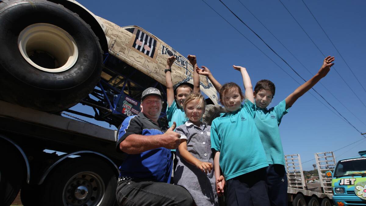 Monster truck driver Troy Garcia introduces his big-wheeled beast to Beau Jans, 10 (left), Jasmine Wylie, 6, Ella Knights, 7, and Ricki Brooks, 9, at West Warrnambool Primary School yesterday. 