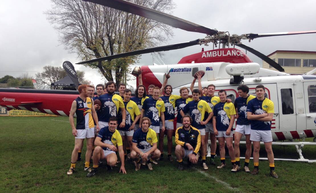 North Warrnambool Eagles reserves players took the opportunity for an unusual team photo in front of the HEMS 4 emergency helicopter after it landed on Leura Oval, Camperdown. Picture: Scott Buck