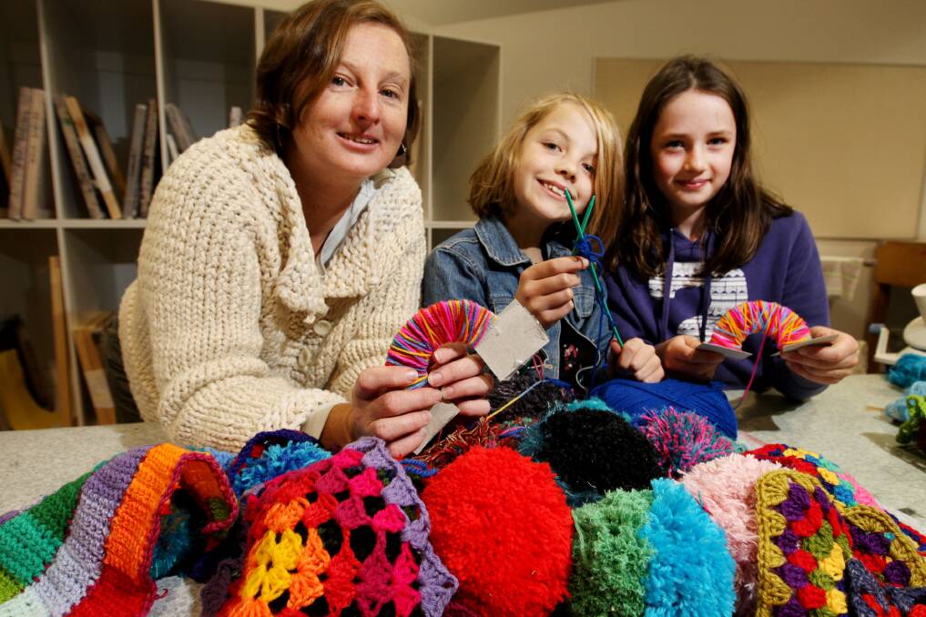 South West TAFE art teacher Karen Richards helps Maisie Rentsch, 8, and Elanora Williams, 9, prepare some of the colourful “bombs”.150523LP06 Picture: LEANNE PICKETT