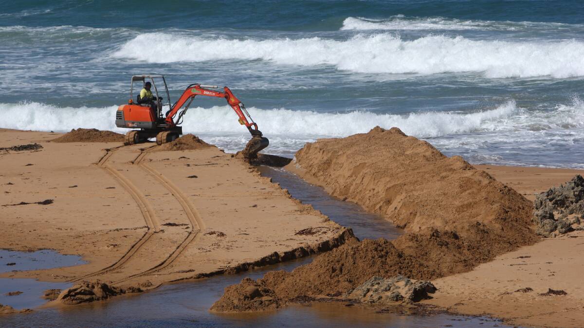 An excavator completes the reopening of the Hopkins River mouth yesterday.