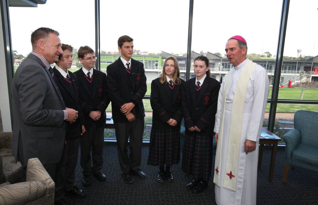 Emmanuel College principal Peter Morgan (left) and students Morgan Couch, 14, Jye Barker, 13, Jack Zanker, 14, Jemma Tanner, 12, and Caitlin Symmons, 12, with the Bishop of Ballarat, the  Most Reverend Paul Bird, at yesterday’s official opening.  140430LP57 Picture: LEANNE PICKETT