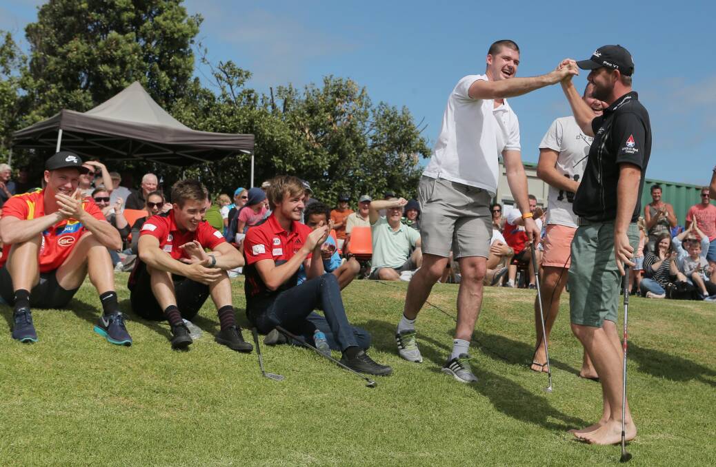 AFL legend Jonathan Brown was the first to congratulate Marc Leishman for his shot, which was also witnessed by AFL players (from left) Louis Herbert, Zac Merrett and Marty Gleeson. 141227LP93 Picture: LEANNE PICKETT