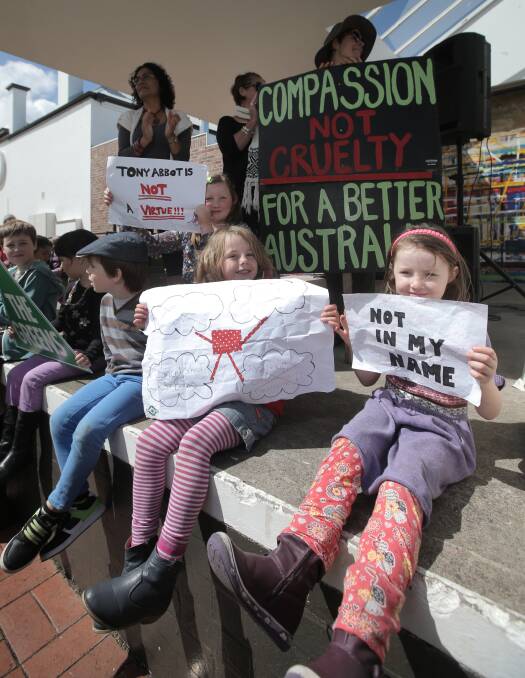 Youngsters Niamh Curran-Webster, 5 (left), and Angela Mainsbridge, 5, from Warrnambool, display posters during yesterday’s March in March protest at the Civic Green.