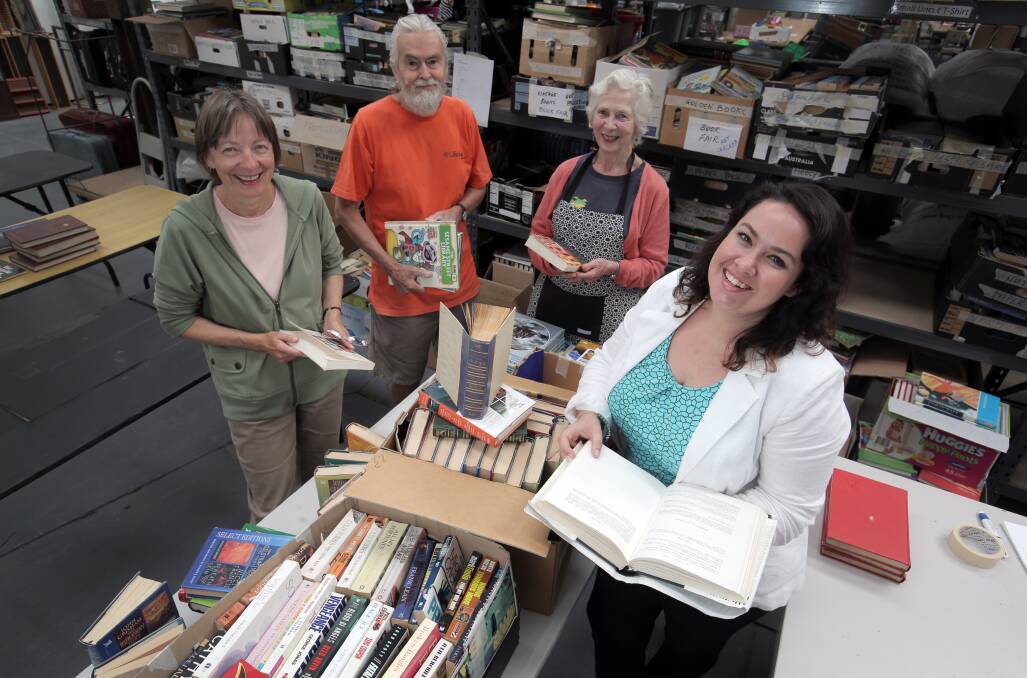 Volunteers Kate Silva (left), Clive Brownsea and Sandra Brownsea help community engagement manager Chloe Brian sort books for the Lifeline Book Fair at Easter. They need more books and volunteers to get the event running. 