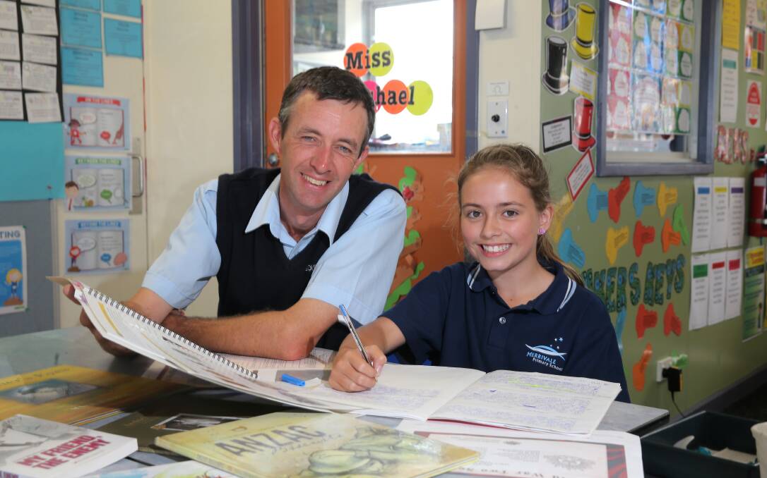 Warrnambool RSL sub-branch memorabilia officer David McGinness casts an approving eye over 11-year-old Rachael Wallace’s work on her commemorative verse at Merrivale Primary School yesterday. 150303VH42 Picture: VICKY HUGHSON