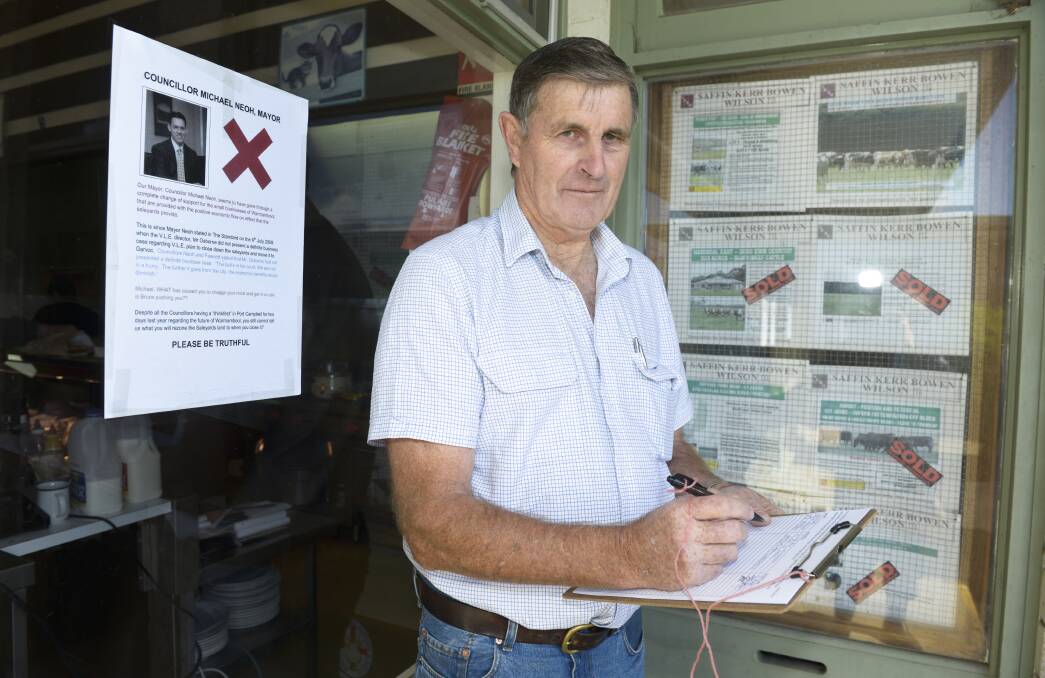 Retired stock agent Rob McCrabb, an advocate for retaining the saleyards, signs a petition for presentation to the city council. 140425SH03  Picture: STEVE HYNES