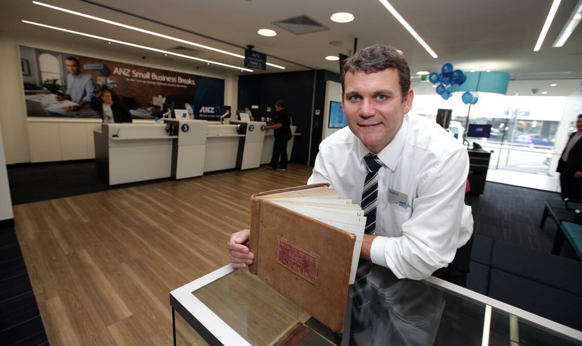 Warrnambool ANZ branch manager Andrew Morris with a 1914 signing-in book in the new offices.