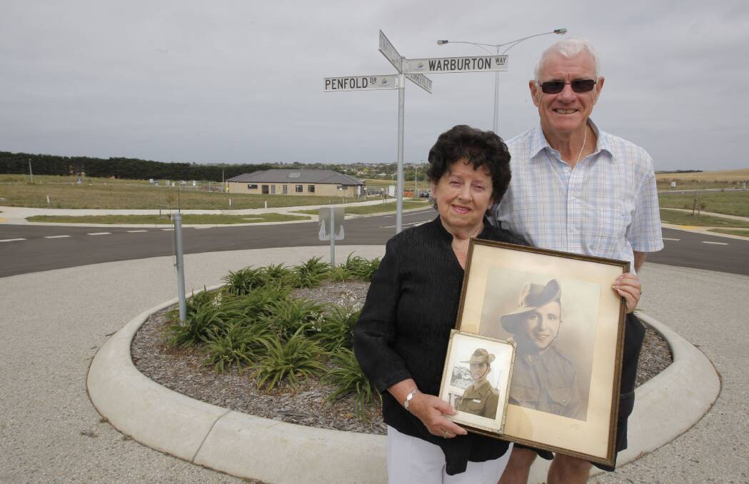 Judith McKenzie holds photographs of her brother, Graham, and uncle, Ossie, at the new street named in their honour, accompanied by school friend of Graham and fellow Vietnam veteran Peter Stapleton, whose brother developed the estate. 150209AM56  Picture: ANGELA MILNE