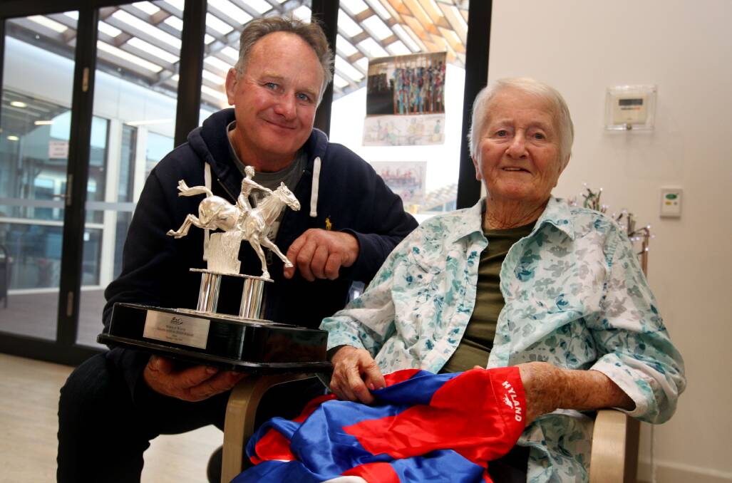 Trainer Colin Chandler shares the Grand Annual Steeplechase trophy and jockey silks with Mercy Place resident Mary Hulin, a former Warrnambool tote worker. 150429LP01 Picture: LEANNE PICKETT