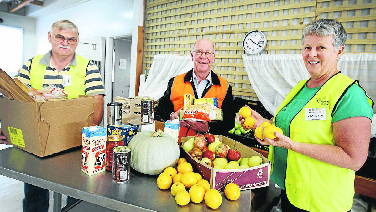 Food Share workers Frank Breed (left), Dedy Friebe and Jeanette Brennan with some of the free food the organisation distributes to those in need. 140423LP16 Picture: LEANNE PICKETT