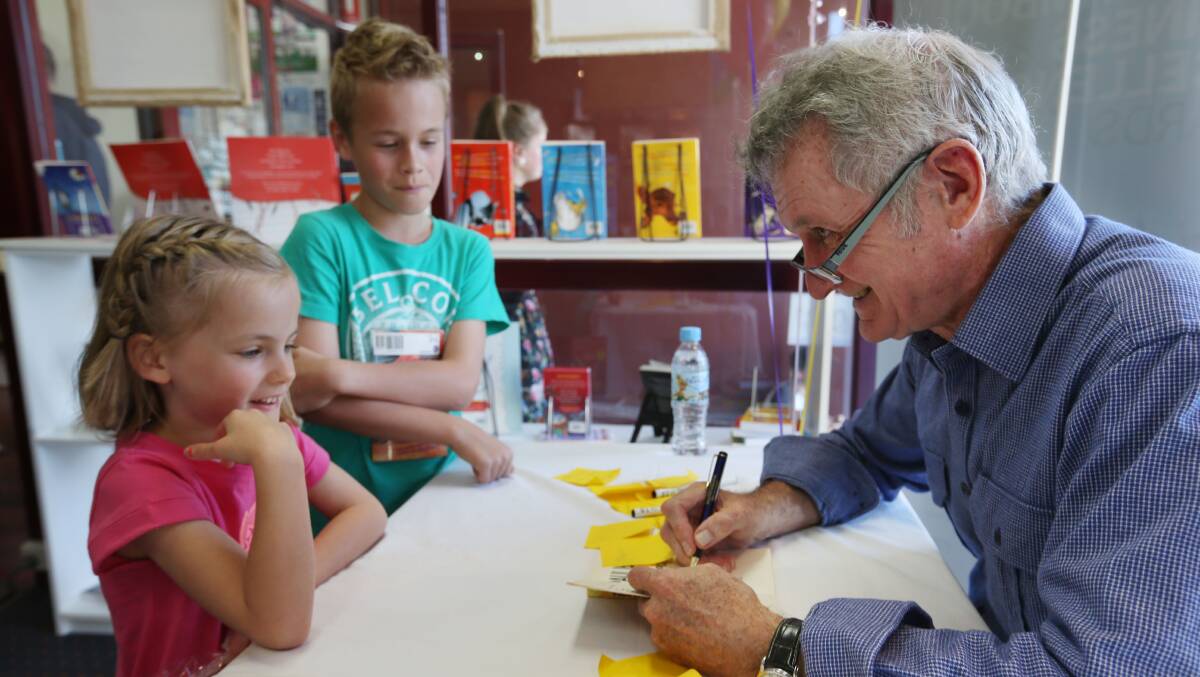 Nairi Fahey, 6, and Eli Fahey, 10, get their books autographed by children’s author Paul Jennings at Warrnambool Books yesterday.