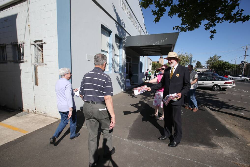 ALP candidate for South West Coast Roy Reekie hands out how-to-vote cards at the Temperance Hall in Warrnambool on Saturday. 141129LP03 Picture: LEANNE PICKETT