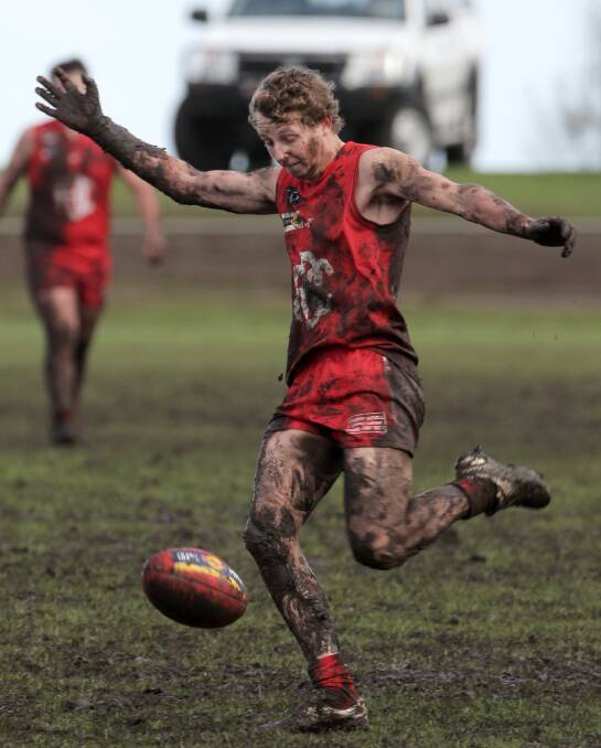 Dennington’s Luke Pearson revels in muddy conditions on the Dogs’ home ground as his team upset premiership contender Allansford by 70 points.
