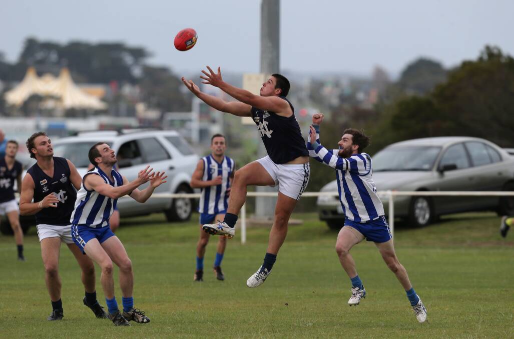 Nirranda full-forward Rick Spokes, surrounded by opposition players, stretches his arms to drag in a mark and kick one of his six goals for the match against Russells Creek yesterday.  The Blues went on to defeat Creek by 101 points.150426DW25  Picture: DAMIAN WHITE