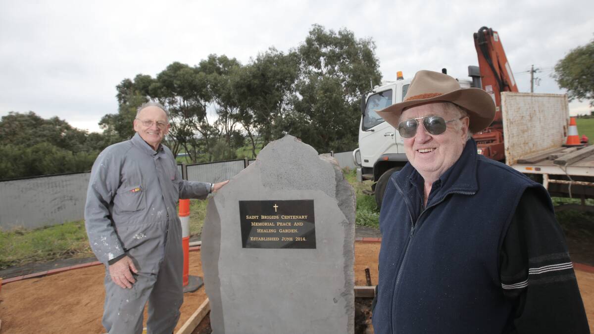 St Brigid’s centenary committee members Mick Lane (left) and Gerry O’Brien work on erecting a bluestone memorial for the celebrations this weekend. 
