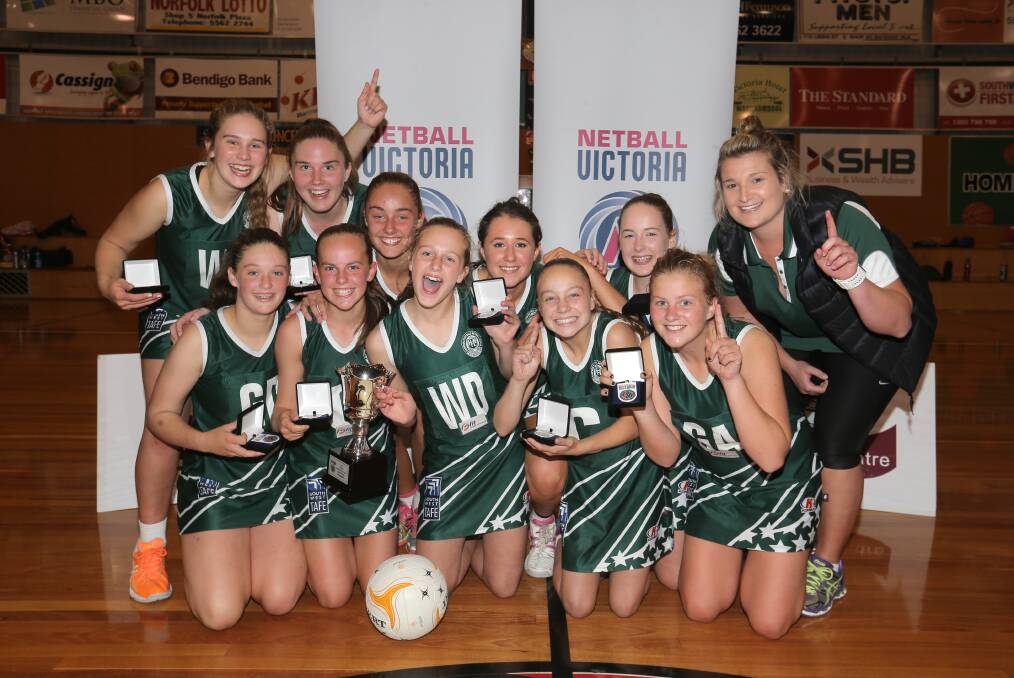 Hampden Green’s 15 and under players share the winning feeling with coach Sarah O’Meara after overpowering Colac & District in last night’s Western Regional State League grand final.