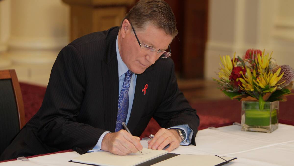 Premier and South West Coast MP Denis Napthine signs the condolence book for the victims of MH17 yesterday.  Picture: The Age