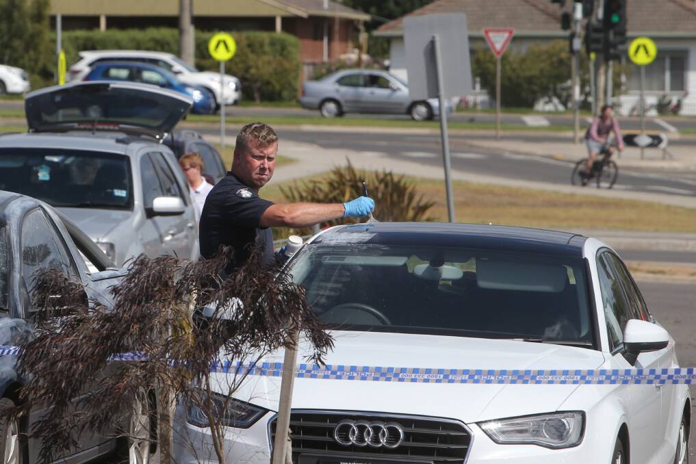 A crime-scene detective dusts the victim’s Audi for fingerprints after the armed robbery.150228AS25 Picture: AARON SAWALL
