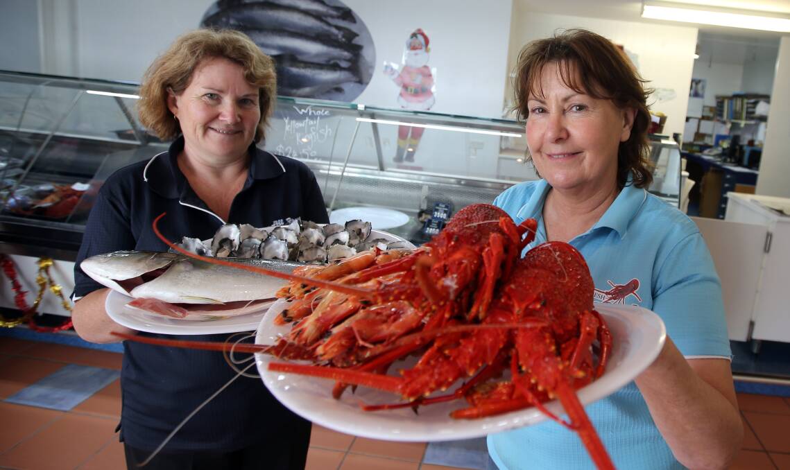 Warrnambool All-Fresh Seafoods’ Kerrie Steel (left) with oysters and yellowtail kingfish and Karen Bond with Hervey Bay prawns and local crayfish. 141223DW37 Picture: DAMIAN WHITE