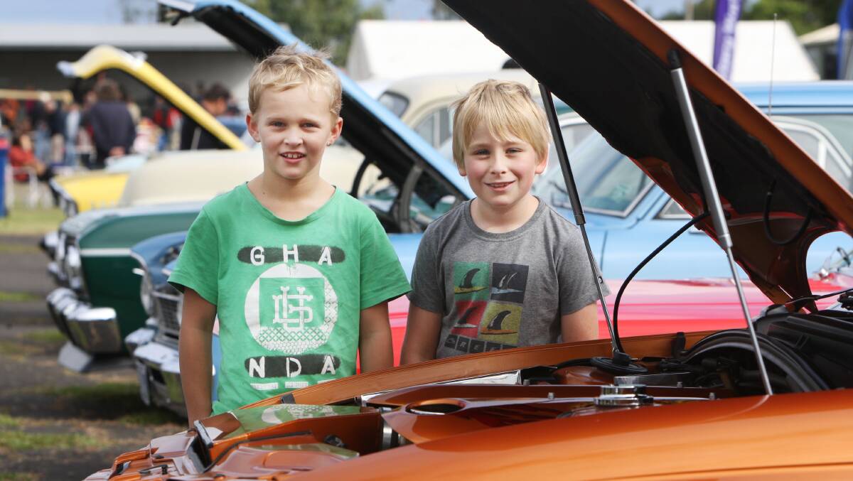 Bailey Watson, 8, of Warrnambool and Henry Rowe, 8, of Koroit looking over a row of cars. 
