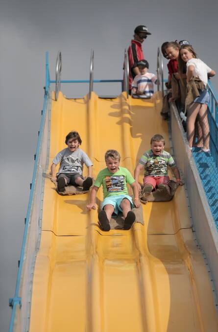 Matthew Edwards, 8, Arley Fleming, 9, and Kelby Fleming, 7, all from Warrnambool, race down the slide.